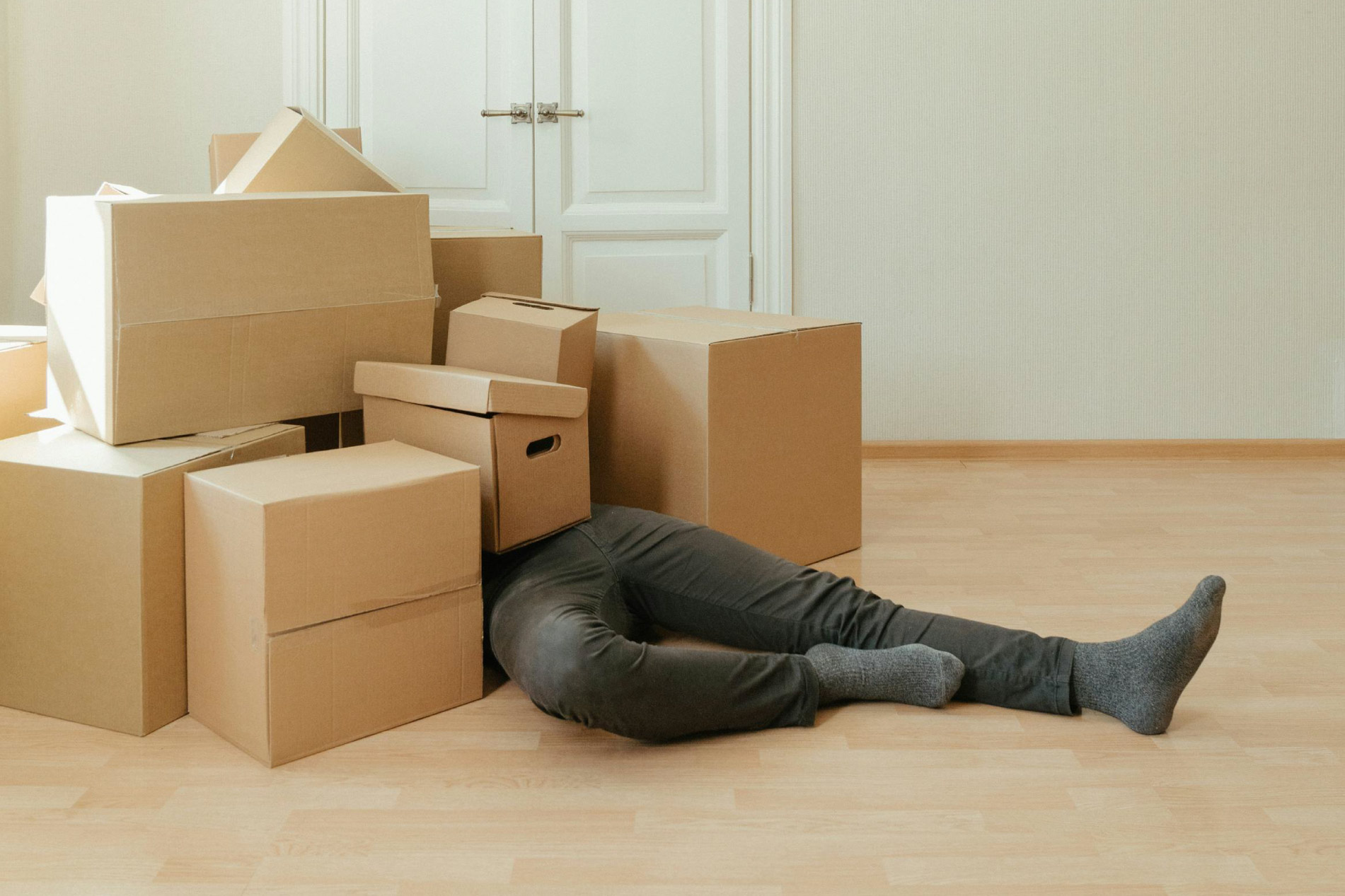A person buried under a pile of moving boxes